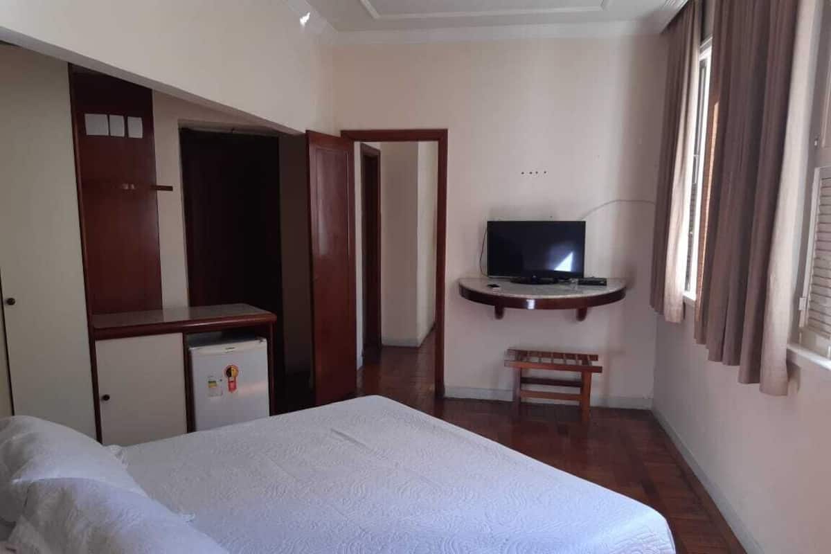 Minibar, escritorio, cortinas blackout y tabla de planchar con plancha