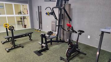 A gym with exercise equipment, a bench, and a stationary bike.