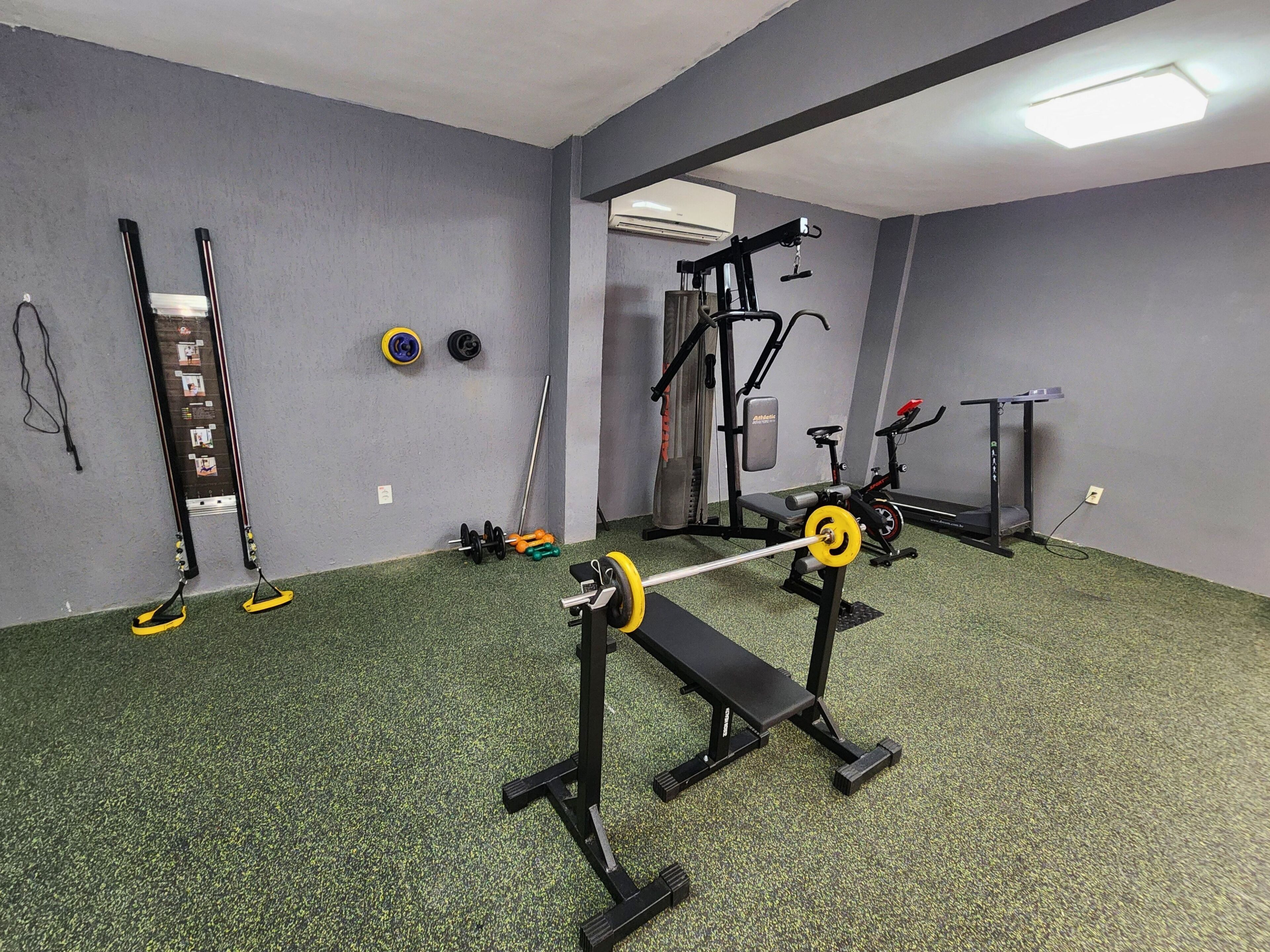 A gym with a pull-up bar, weight bench, and various exercise equipment.