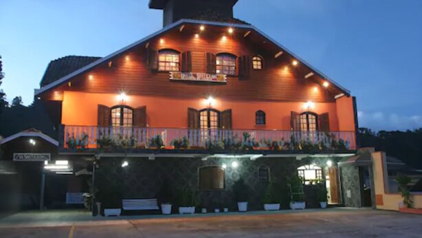A two-story building with a balcony and a sign that reads "The Lodge." - Shallon (Campos do Jordão)