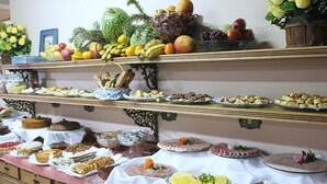 A buffet with various food items including fruits, pastries, and desserts. - Shallon (Campos do Jordão)