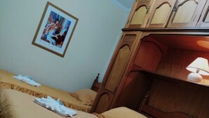 A hotel room with two beds, wooden headboards, a framed picture on the wall, and a bedside lamp. - Shallon (Campos do Jordão)