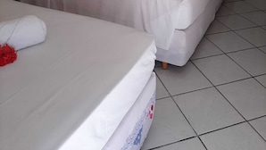 A hotel room with two beds, a wooden headboard, a small table, and a chair. - Marbello Ariaú Hotel (Fortaleza)