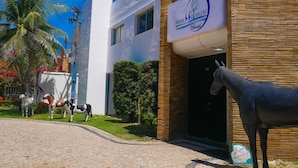 A building with a sign reading "Marble & Coralá Brasil" and a horse statue in front. - Marbello Ariaú Hotel (Fortaleza)