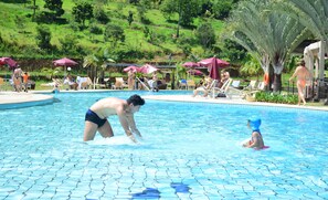 Una piscina cubierta, una piscina al aire libre, sombrillas, tumbonas