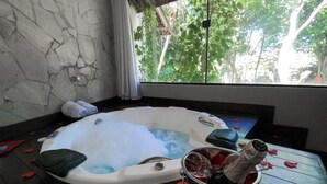 A hot tub with a stone wall and a view of trees outside. - Brasil Tropical Village (Tibau do Sul)