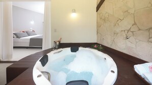 A bathroom with a bathtub, a shower, and a toilet. There is a wooden bench in the bathroom. - Brasil Tropical Village (Tibau do Sul)