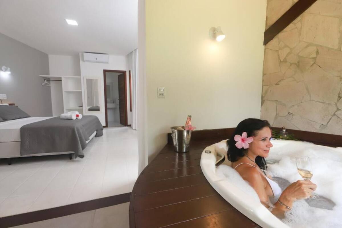 Una habitación con cama, baño con bañera y comedor.