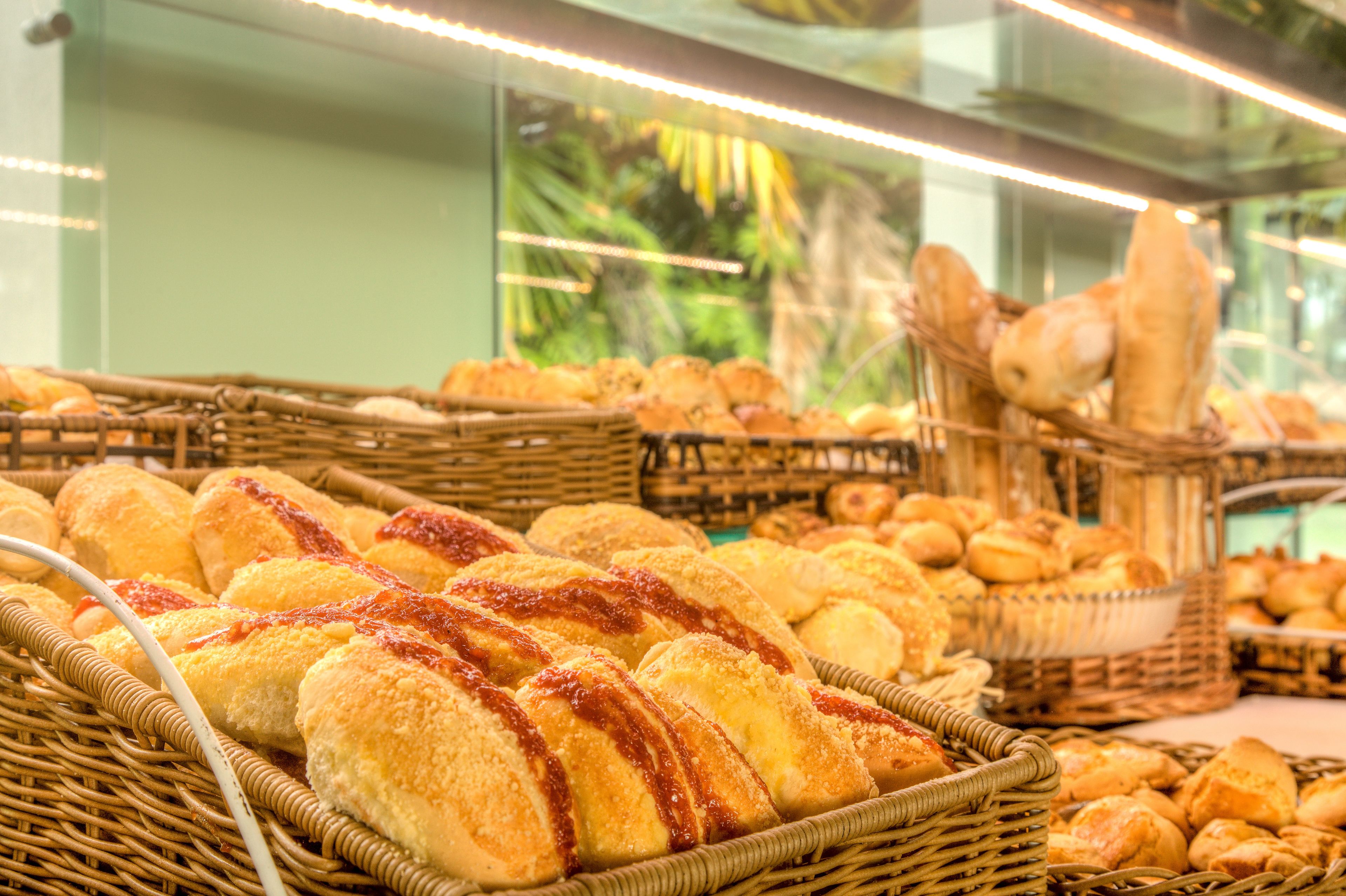 A bakery display with various breads and pastries in wicker baskets.