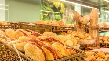 A bakery display with various breads and pastries in wicker baskets.