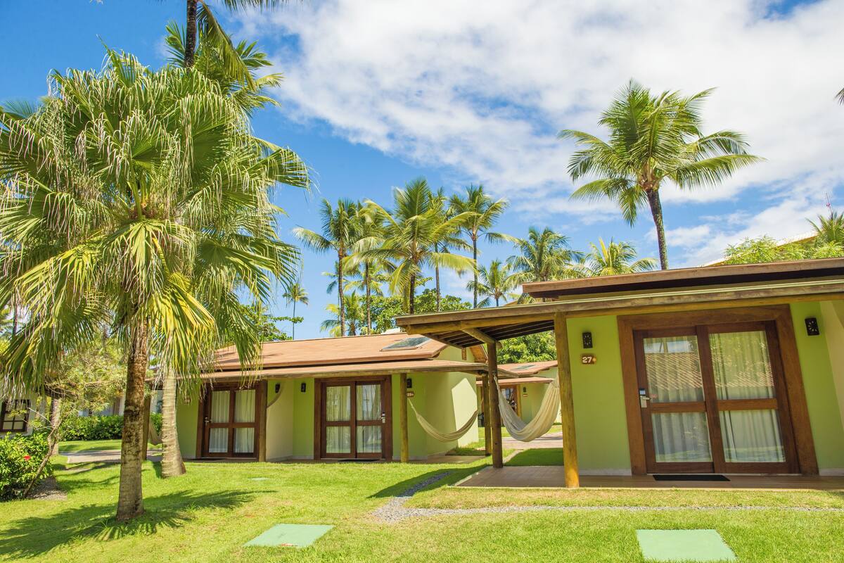 Un resort con dos habitaciones, cada una con entrada privada y una hamaca.