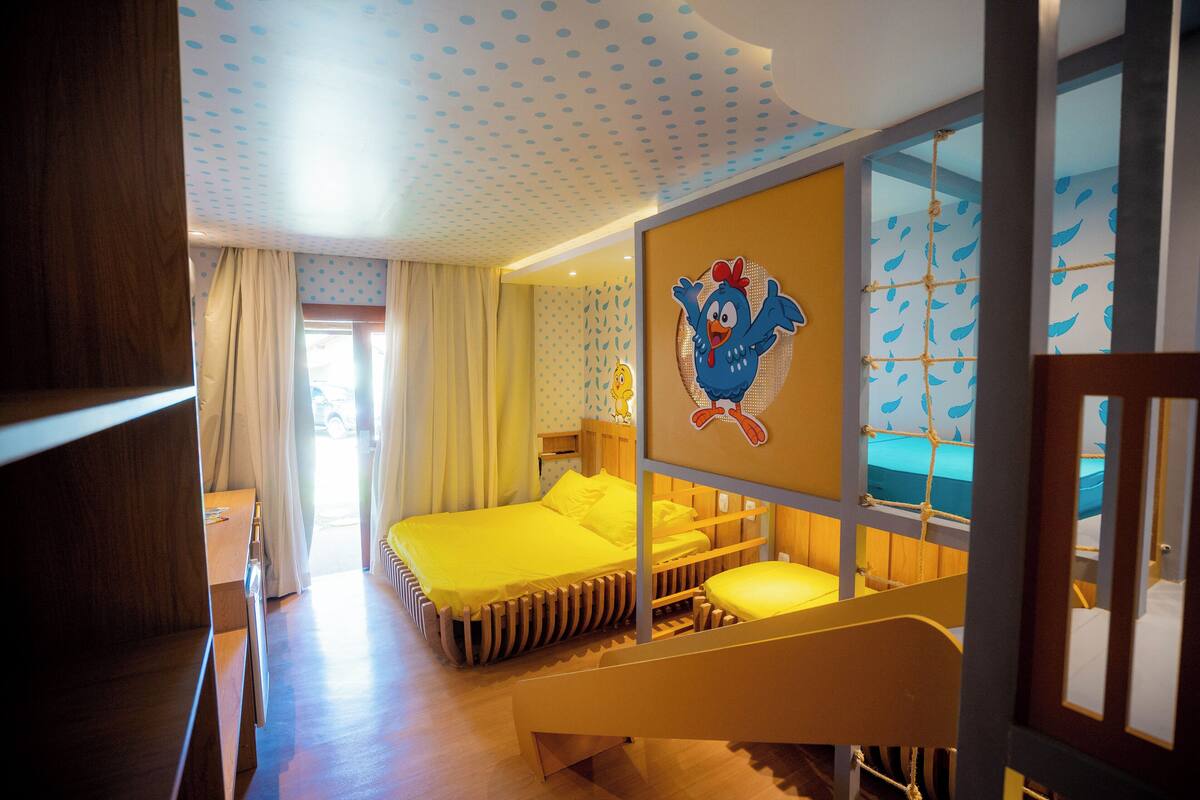 Una habitación con literas, un escritorio de madera y una ventana con cortinas.