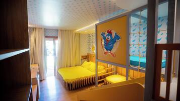 Um quarto com cama beliche, escrivaninha de madeira e janela com cortinas.