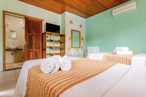 Habitación de hotel con dos camas, un armario de madera, un baño con lavamanos y un aire acondicionado de pared.