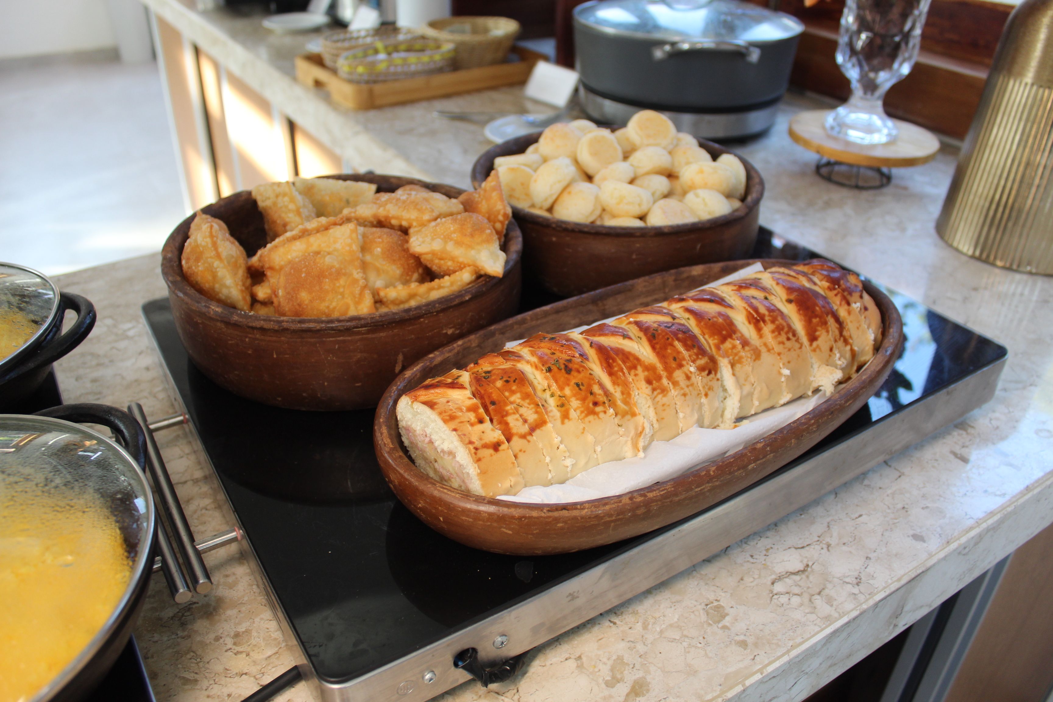 EinBuffet mit verschiedenen Speisen, darunter ein Brotlaib, Schüsseln mit Chips und ein Suppentopf.