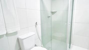 Un baño moderno con ducha envuelta en vidrio, inodoro y bidé.