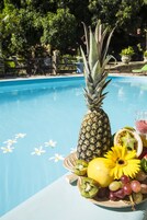 Una piscina al aire libre, sombrillas, sillones reclinables de piscina