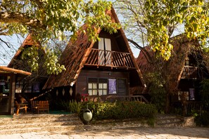 A traditional wooden house with a thatched roof, a balcony, and a stone pathway leading to the entrance. - Chalet Suisse (Natal)