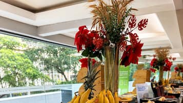 A buffet with various food items including fruits, pastries, and desserts.