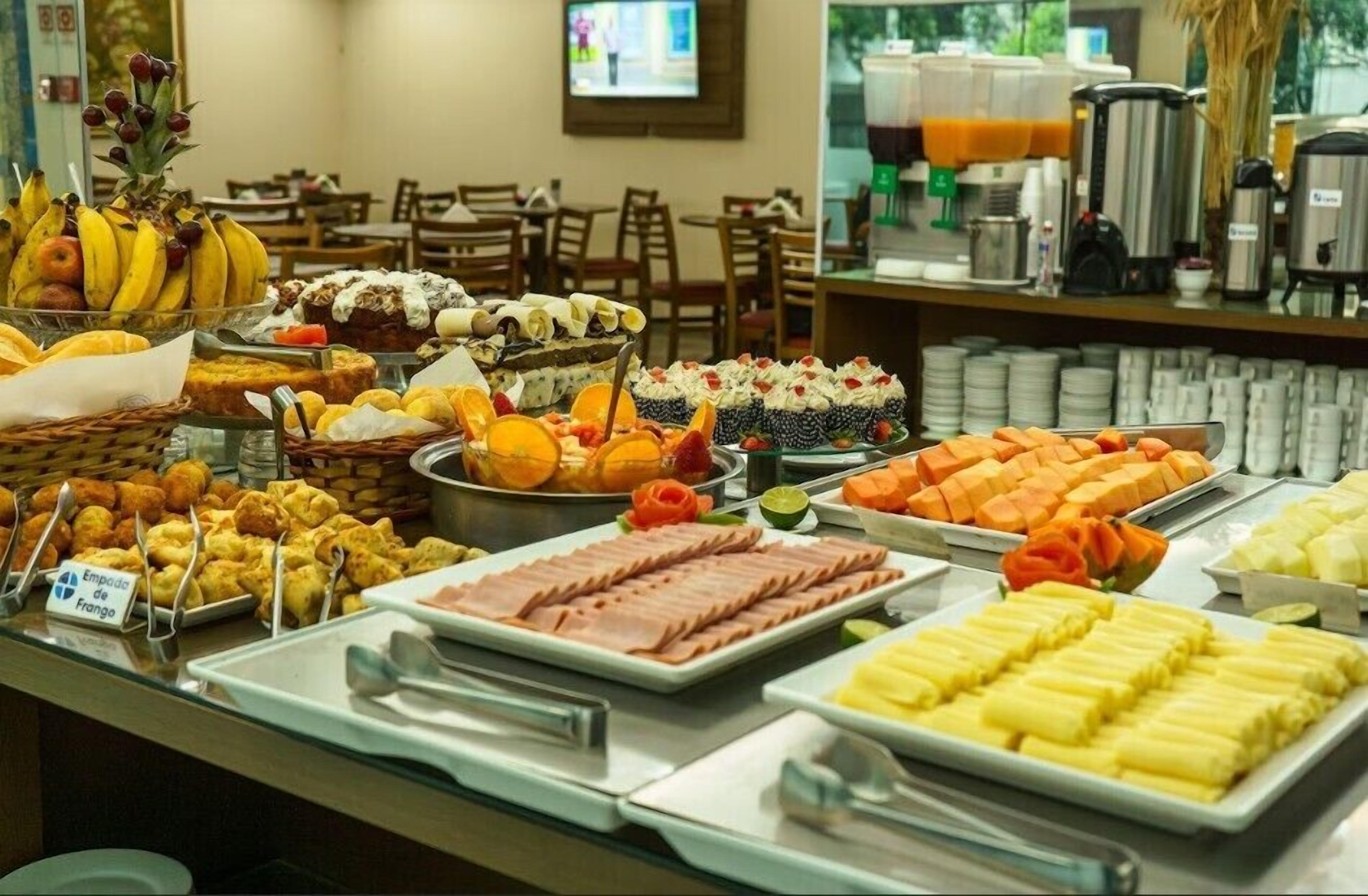 Ein reichhaltiges Buffet mit verschiedenen Speisen, darunter Obst, Gebäck und Fleisch.