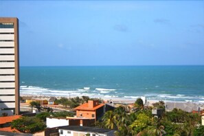 Vista costera con un edificio, océano y playa.