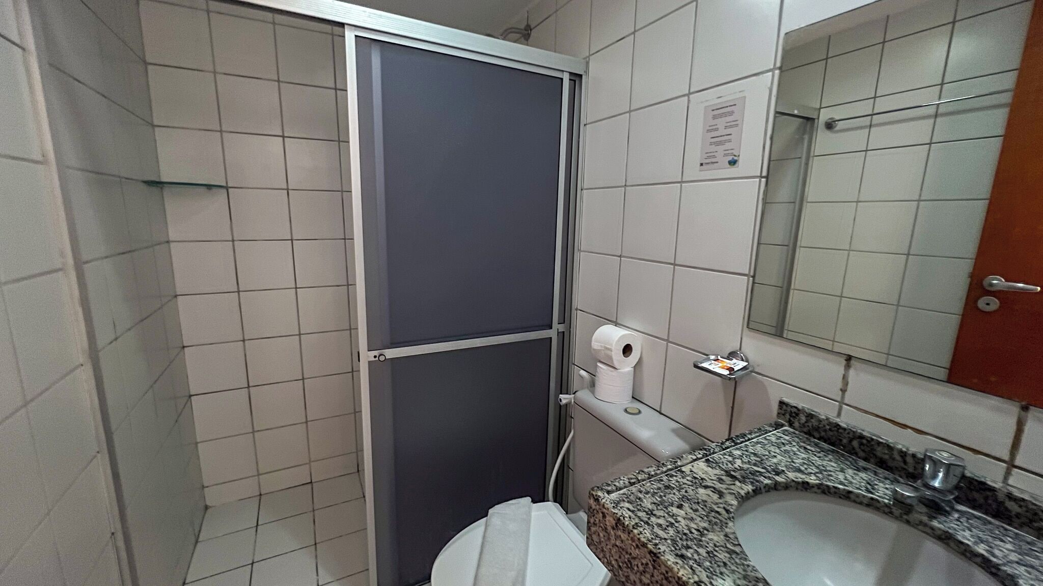 Um banheiro pequeno com vaso sanitário, pia e espelho.