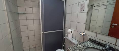 Um banheiro pequeno com vaso sanitário, pia e espelho.