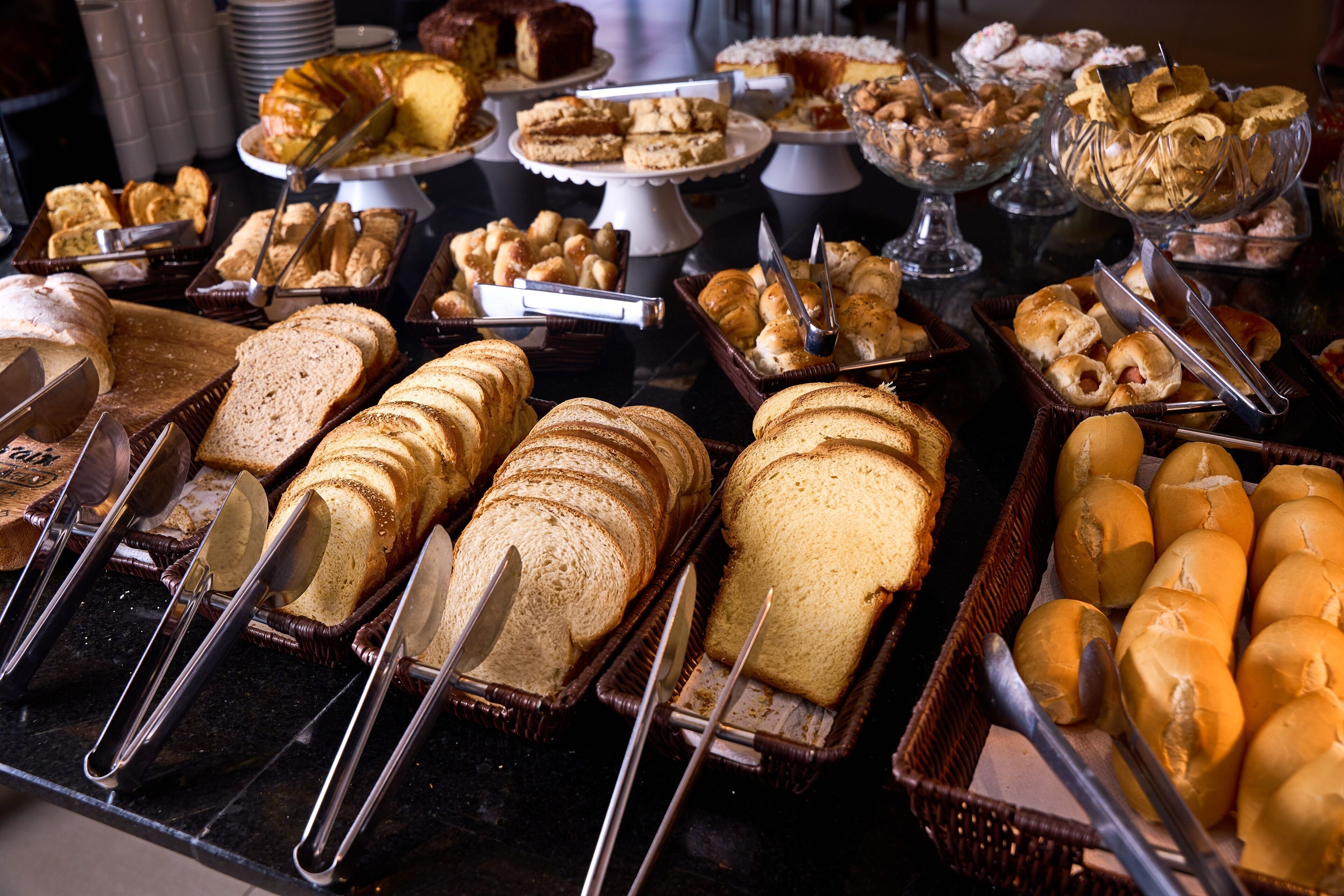 A buffet with various breads and pastries.