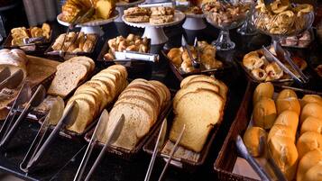 A buffet with various breads and pastries.