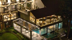 A multi-story hotel with a rooftop pool area, outdoor dining, and multiple balconies. - Hotel Alpestre (Gramado)