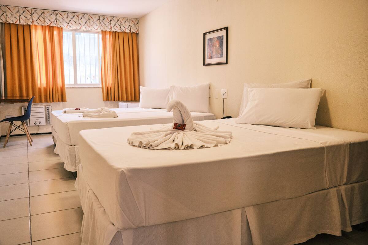 Ett hotellrum med två sängar, ett skrivbord och en stol.