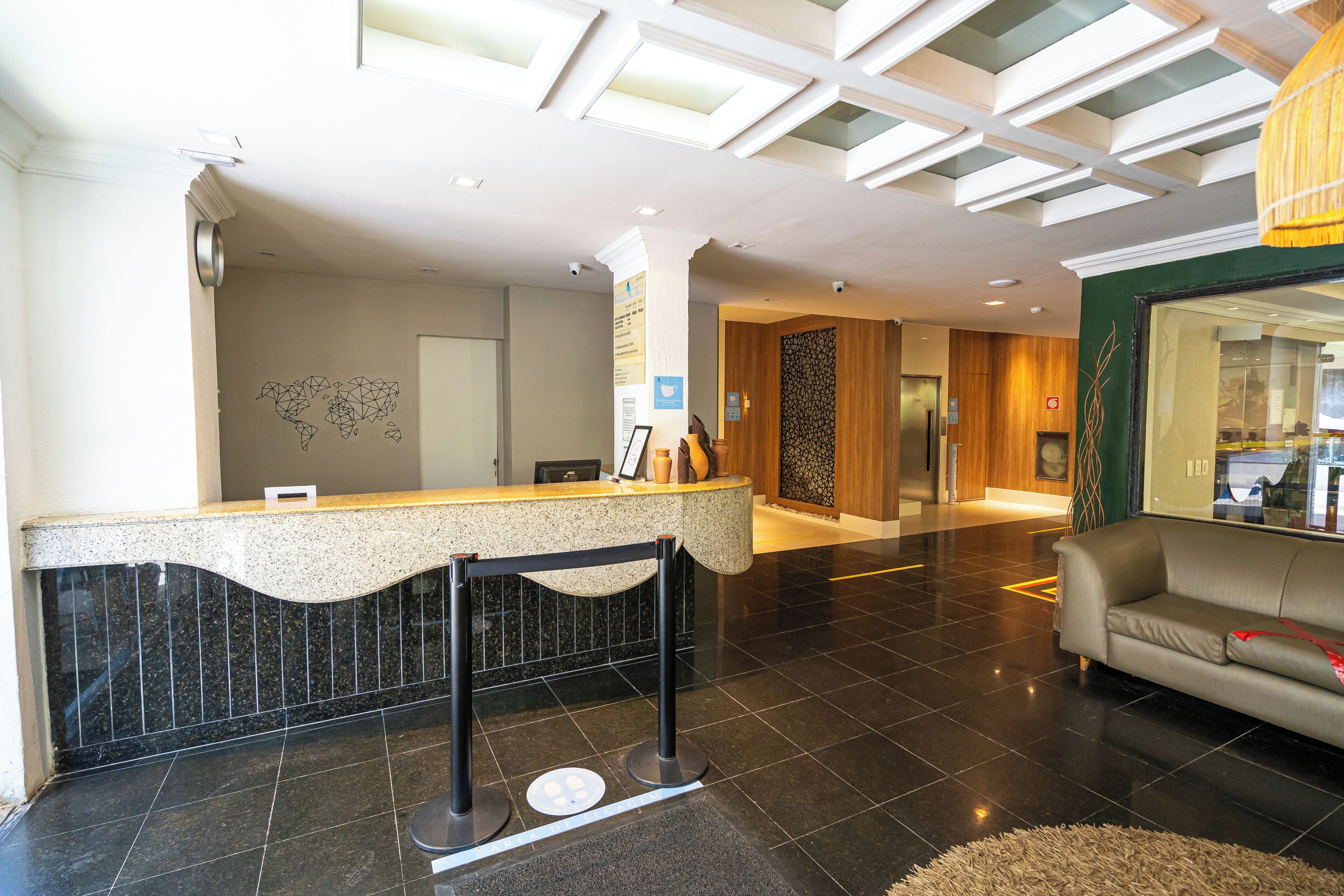 A hotel reception area with a reception desk, a sofa, and a modern interior design.