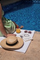 Una piscina al aire libre, sillones reclinables de piscina