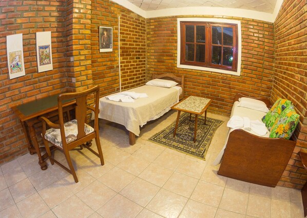 A room with a bed, a desk, a chair, a small table, and a sofa. - Real Pousada (Ipojuca)