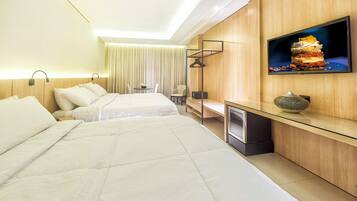 A hotel room with two beds, a desk, a television, and a small table with a plant.