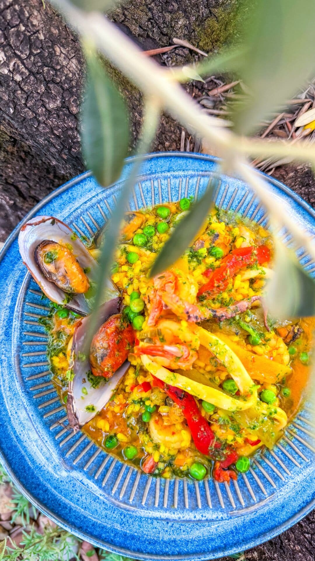 Prato de frutos do mar com mexilhões e legumes numa tigela azul.