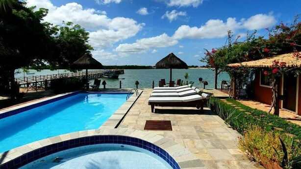 Una piscina con sillones de descanso y vistas al mar.