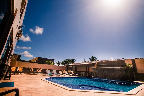 Alberca al aire libre y camastros 