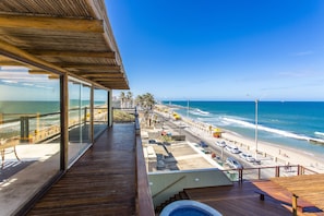 A wooden deck with a view of the beach and ocean. - Porto Suites Natal Hotel (Natal)