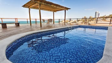 Una piscina al aire libre, tumbonas