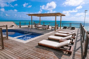 Una piscina al aire libre, sillones reclinables de piscina