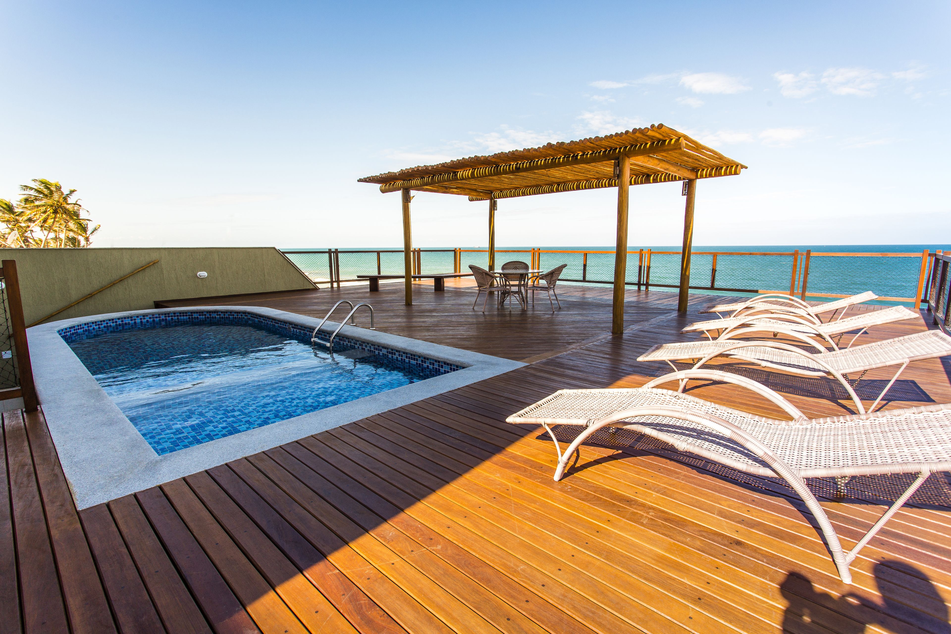 Una piscina al aire libre, sillones reclinables de piscina