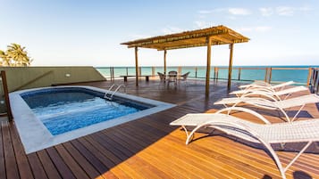 Una piscina al aire libre, sillones reclinables de piscina