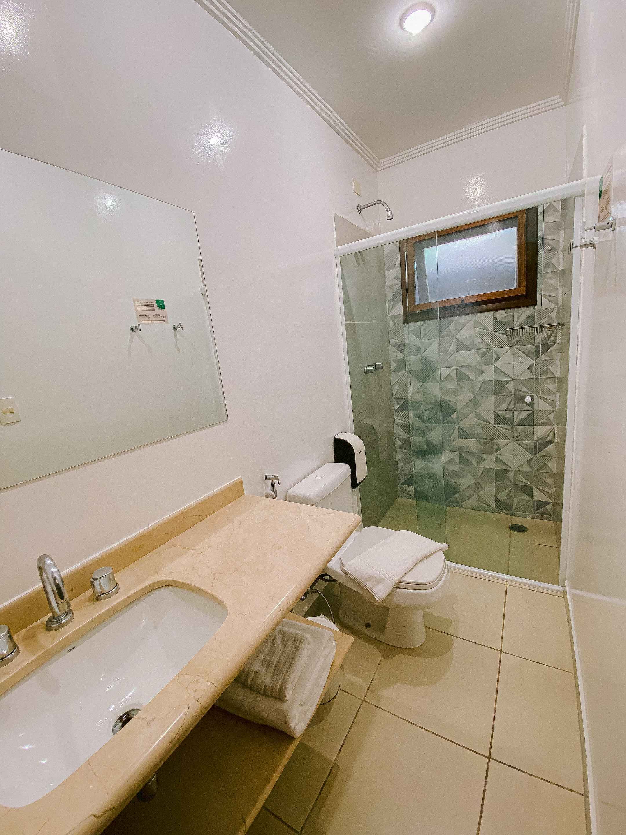 Un baño con bañera, lavamanos, inodoro y zona de ducha.