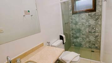 Un baño con bañera, lavamanos, inodoro y zona de ducha.
