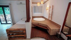 A bathroom with a wooden vanity, a bathtub, and a shower area. - Pousada Porto Mare (São Sebastião)