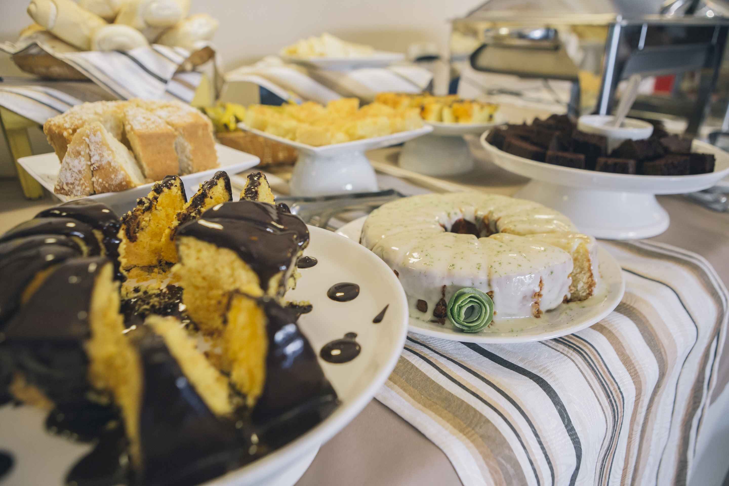 Una mesa de bufé con diversos postres, incluyendo pasteles y repostería.