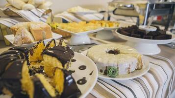 Una mesa de bufé con diversos postres, incluyendo pasteles y repostería.