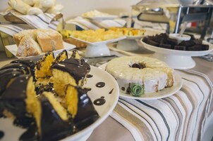 Una mesa de bufé con diversos postres, incluyendo pasteles y repostería.