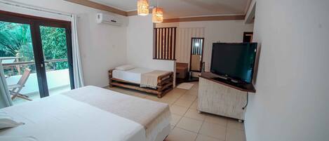 A hotel room with two beds, a TV, and a balcony with a chair.